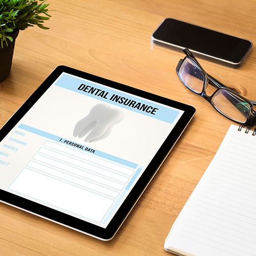 Tablet with Dental Insurance on it and glasses