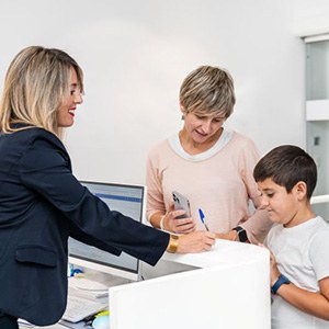Mother and son standing at dental office front desk