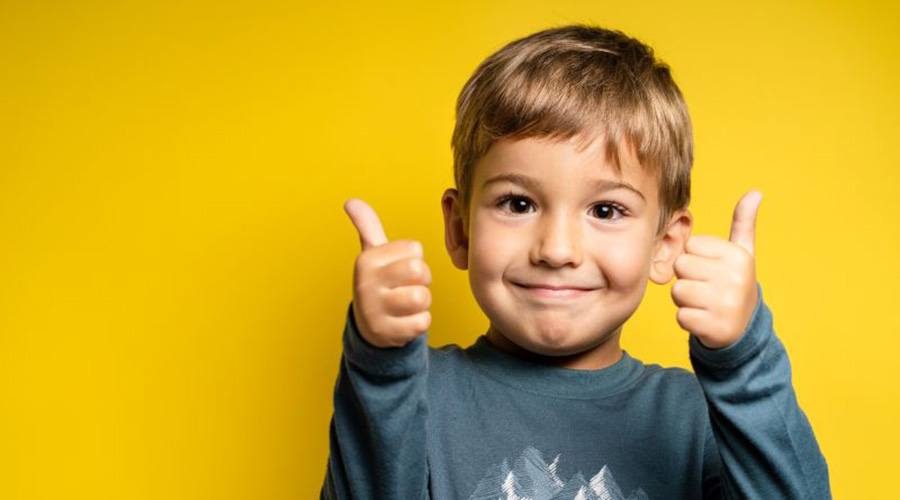 Happy little boy making thumbs up gesture