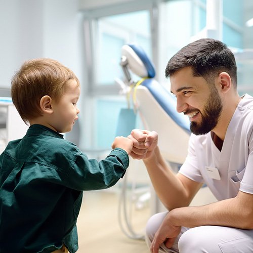 Dental team member giving fist bump to small child