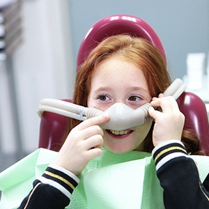 Child smiling while holding nasal mask