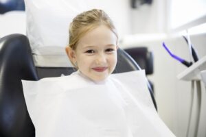 Young girl smiling in dentist’s chair.